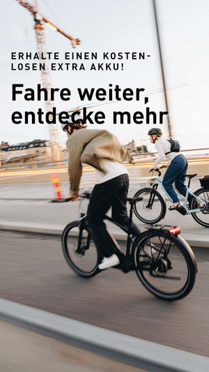 Aktionsanzeige: "Erhalte einen kostenlosen extra Akku! Fahre weiter, entdecke mehr", im Hintergund zwei Personen auf ihren Fahrrädern fahrend