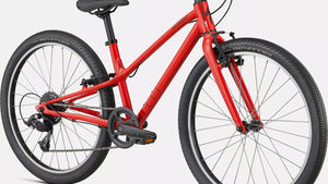 Kinderfahrrad in glänzendem rot, schräge Ansicht von Vorne auf weißem Hintergrund