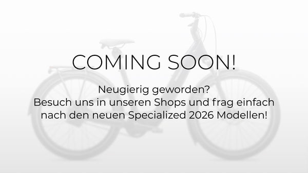 Bildaufschrift: "Coming Soon! Neugierig geworden? Besuch uns in unseren Shops und frag einfach nach den neuen Specialized 2026 Modellen", Platzhalterbild, da Produktbild noch nicht vorhanden, im Hintergund dezent ein verschwommen abgebildetes E-Bike