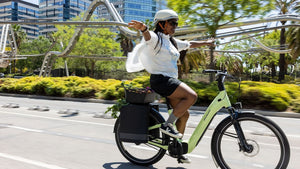 Eine Person fährt freihändig auf ihrem Specialized Como E-Bike durch eine urbane Umgebung